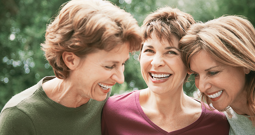 Three women smiling in a group